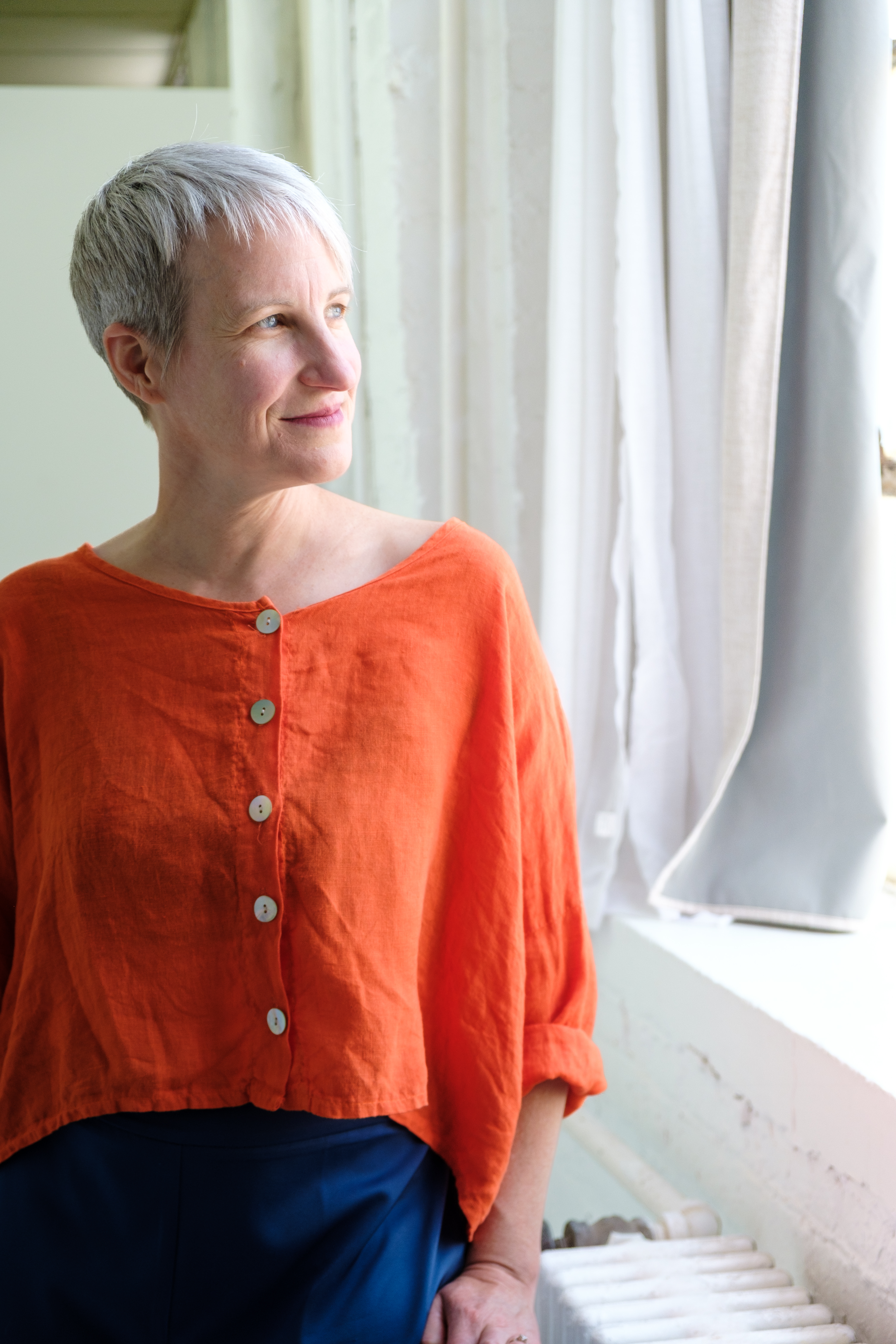 Kristen Peairs looking toward the light in an orange top